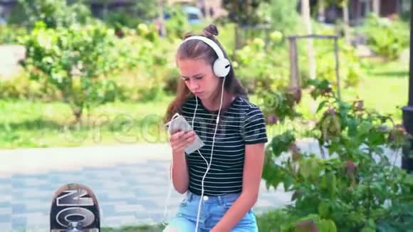 坐在长椅上听音乐的女孩视频的预览图