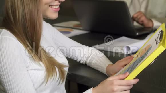 在办公室工作的时候一个美丽的女人正笑着视频的预览图