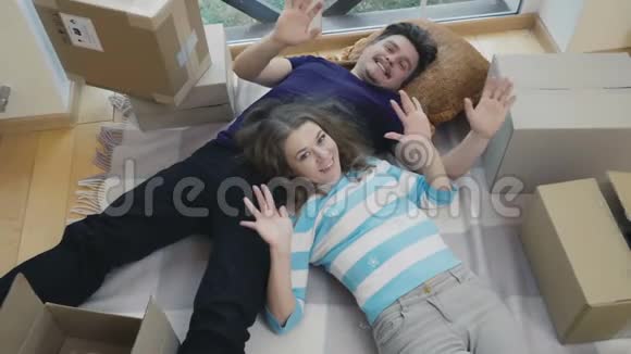 幸福的妻子和丈夫在新房子的拆包箱里挥手视频的预览图