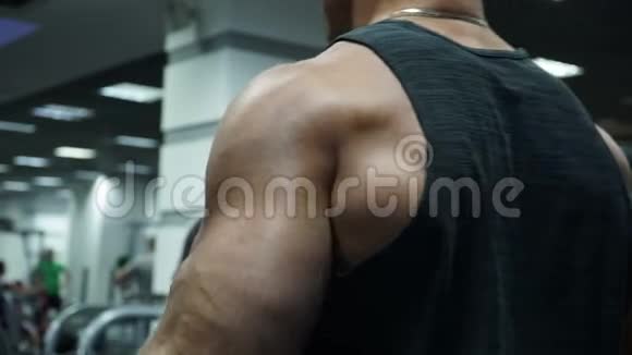 运动员在健身房里用手工作他举起杠铃在二头肌上工作视频的预览图