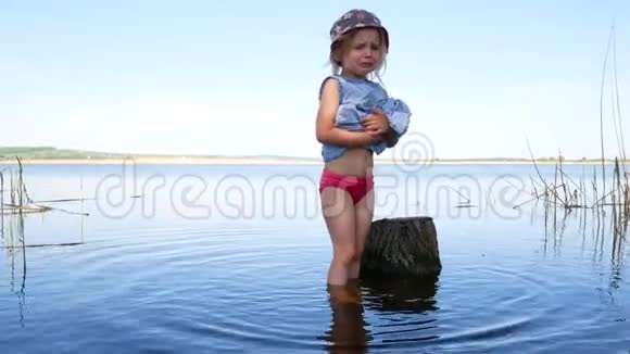 小女孩拿着裙子从湖里出来视频的预览图