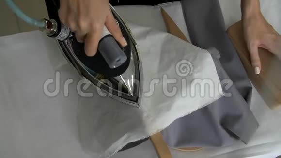 女性的手缝在裁缝的铁灰色布上以便与她进一步合作视频的预览图