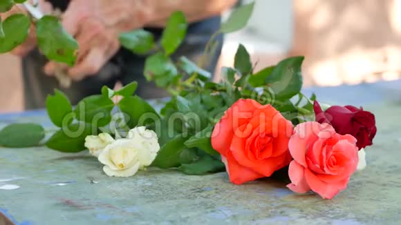 花店用粉色白色和红色玫瑰做花束的花商女士视频的预览图