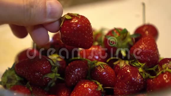 男士手拿新鲜和成熟的草莓视频的预览图