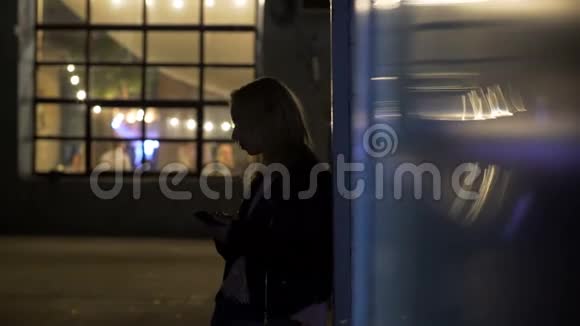 孤独的女孩站在夜总会附近的小巷里叫出租车夜生活视频的预览图