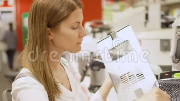年轻女子在商店买厨房用具捡起深油炸格栅背景白色商品视频的预览图