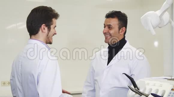 成熟的男牙医与同事握手视频的预览图
