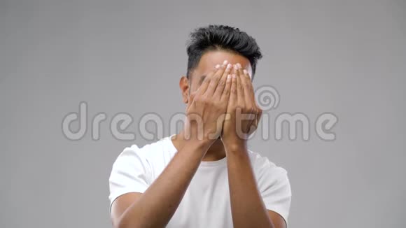 年轻的印度笑男人灰色背景视频的预览图