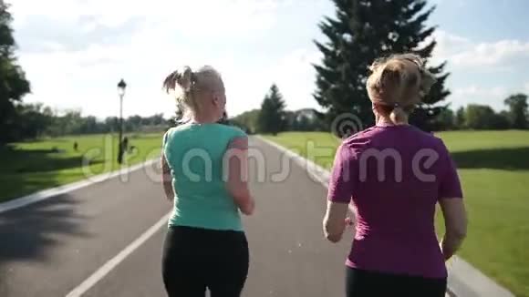 在公路上跑步的资深健身女性的后景视频的预览图