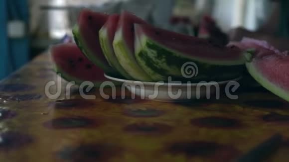 在盘子里的桌子上剪成一片熟西瓜视频的预览图