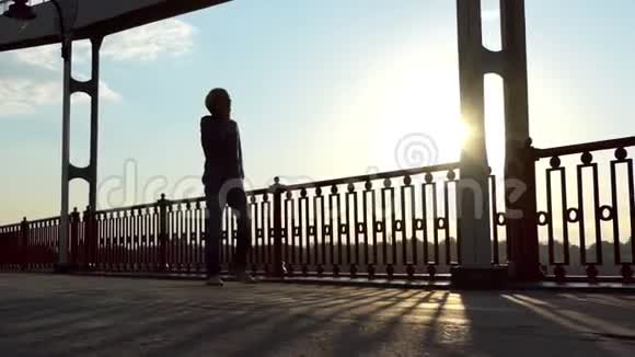 年轻人在斯隆莫的夕阳下高举一座桥快乐地奔跑视频的预览图