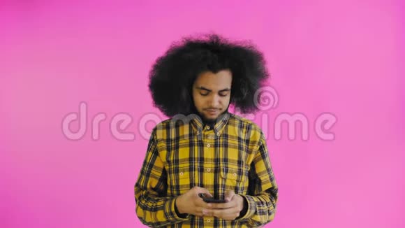年轻英俊的非裔美国人在紫色背景下使用电话情感概念视频的预览图