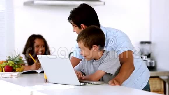 父亲带着儿子和母亲看着笔记本电脑进来帮助女儿视频的预览图