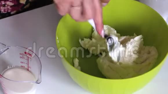 女人在软奶酪上加入糖粉和奶油为蛋糕准备奶油视频的预览图