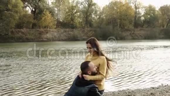 在公园里有几个拥抱和亲吻背景是河秋天的心情视频的预览图