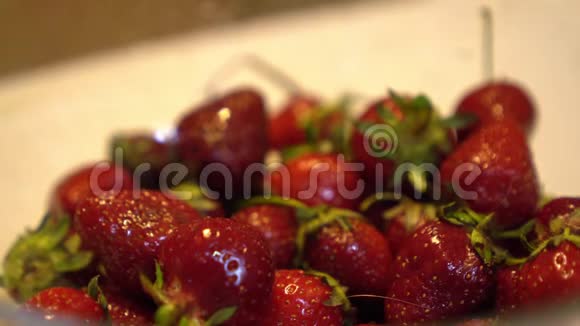 手摇动透明的玻璃碗与新鲜和成熟的草莓关闭视频的预览图