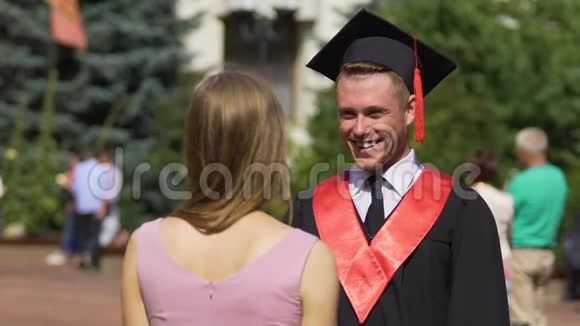 美丽的女人祝贺男友毕业幸福的情侣拥抱视频的预览图