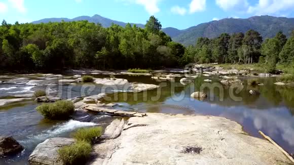 河流中的石头与树木和山丘的景观视频的预览图