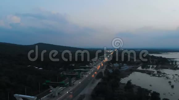 傍晚时分无人机拍摄大河公路交通道路的鸟瞰景观视频的预览图