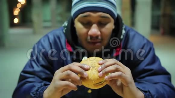 饥饿的流浪汉吃美味的汉堡慈善垃圾食品和健康问题视频的预览图
