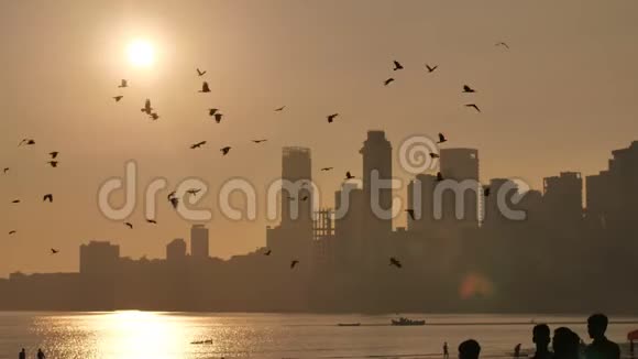 孟买摩天大楼背景下的日落从乔帕蒂海滩欣赏风景视频的预览图