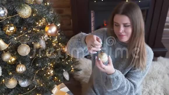 年轻迷人的高加索女人用金球圣诞夜圣诞安排花环和视频的预览图