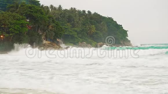 海浪拍打着一个有棕榈树的热带岛屿的海岸强烈的波浪风暴视频的预览图