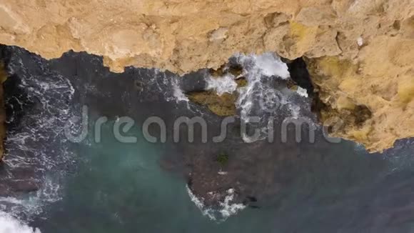 自然光下岩石附近海浪的高空俯视图视频的预览图