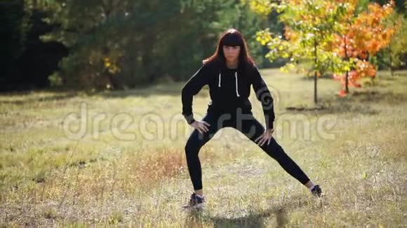 一个身穿运动服的女人在夏季公园训练前伸展肌肉视频的预览图
