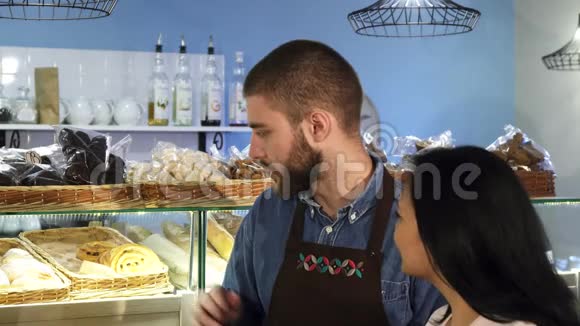 专业的男面包师在他的店里工作帮助他成熟的女顾客视频的预览图