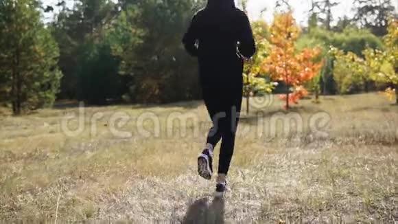 秋天少女在离森林不远的草地上奔跑视频的预览图