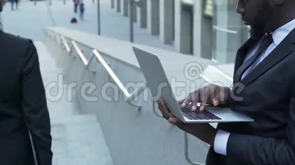一个在手提电脑上工作的商人被一个漂亮优雅的女人路过视频的预览图
