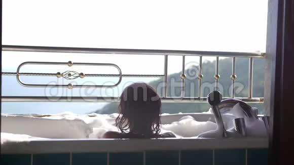 年轻女性沐浴后可以在泡沫浴缸中放松在热带度假胜地享受女孩水疗视频的预览图
