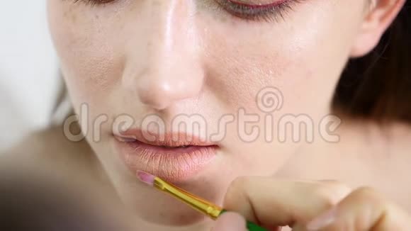 一位专业化妆师将口红涂在模特的嘴唇上从事美容时尚行业视频的预览图
