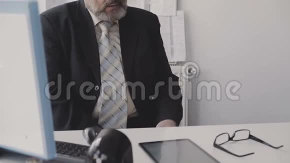 高级老板在办公室橱柜里用笔记本电脑工作4K视频的预览图