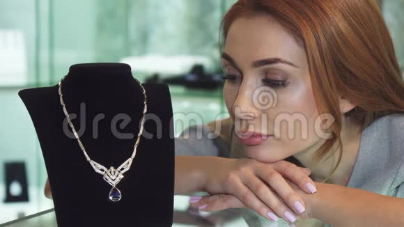 悲伤的女人在商店里摆着一条昂贵的钻石项链视频的预览图