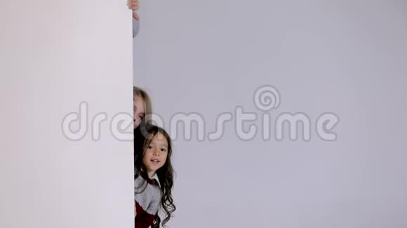 孩子们从白色空白标语牌后面往外看视频的预览图