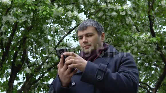 一个严肃的人在苹果树的背景上视频的预览图