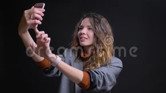 正面高加索年轻女性在电话中自拍微笑合影特写视频的预览图