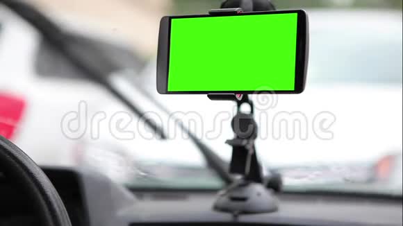 智能手机在汽车仪表板的支架上有一个绿色屏幕视频的预览图