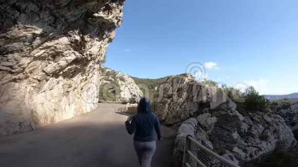 年轻女子独自走在法国加拉默斯峡谷的旅游公路上视频的预览图