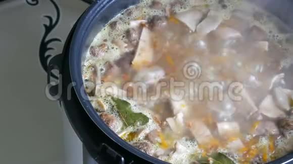 锅里煮蘑菇汤配胡萝卜湾土豆片和香料近景视频的预览图