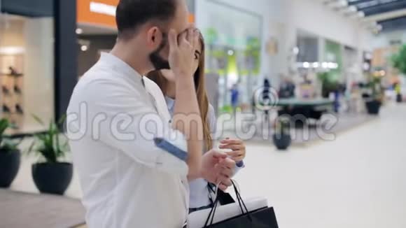 商场里的一对夫妇站在店面前面挑选商品视频的预览图