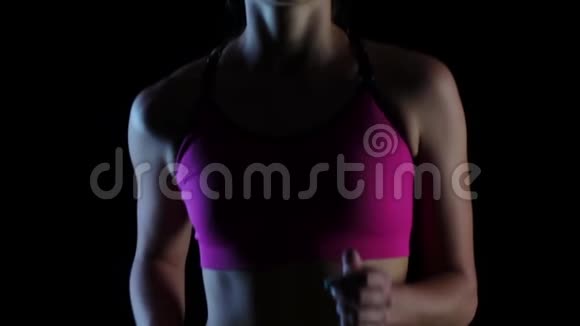 躯干女运动员在黑色背景下跑步慢动作关门视频的预览图