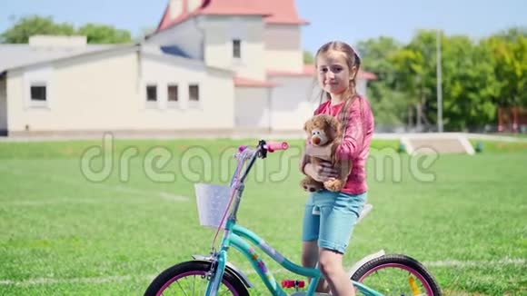 一个可爱的小女孩坐在自行车上的肖像视频的预览图