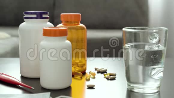 桌子上有药片胶囊温度计和一杯水视频的预览图