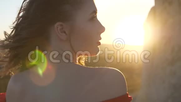 黄昏时分年轻女子被太阳照亮的轮廓视频的预览图