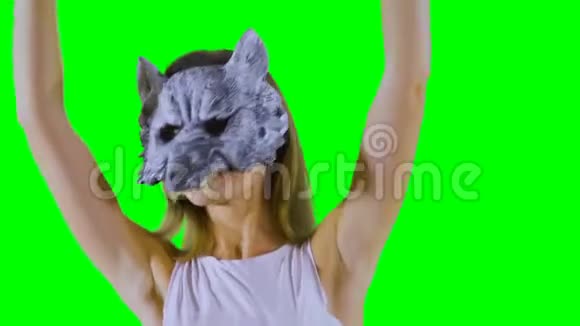 戴着狼面具的快乐女孩在绿色背景下跳舞竖起大拇指视频的预览图