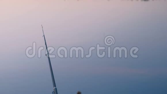 日落时分钓鱼钓鱼竿过池塘视频的预览图