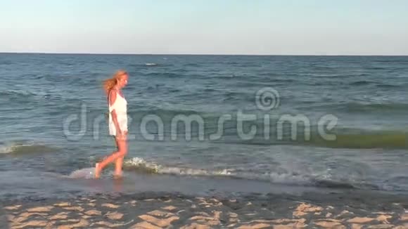 美丽的女人正在海边散步视频的预览图